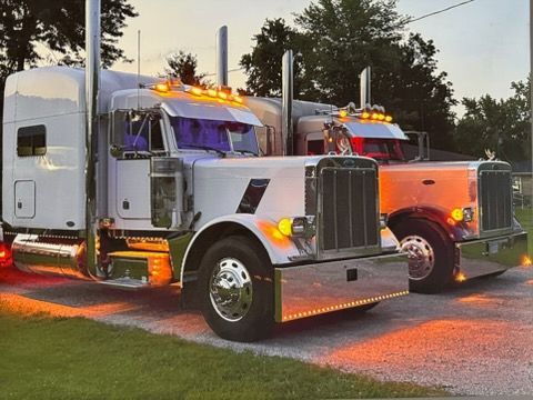 Overhead view of parked semi-trucks in a lot, with trailers in rows.