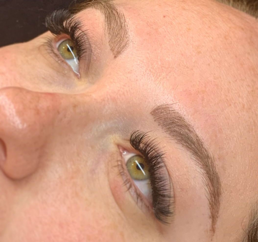 A close up of a woman 's face with long eyelashes.