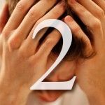 A man is covering his face with his hands and the number two is on the bottom.