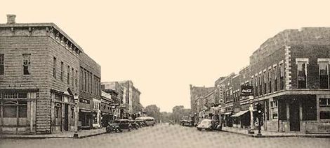 A black and white photo of a city street with a lot of buildings