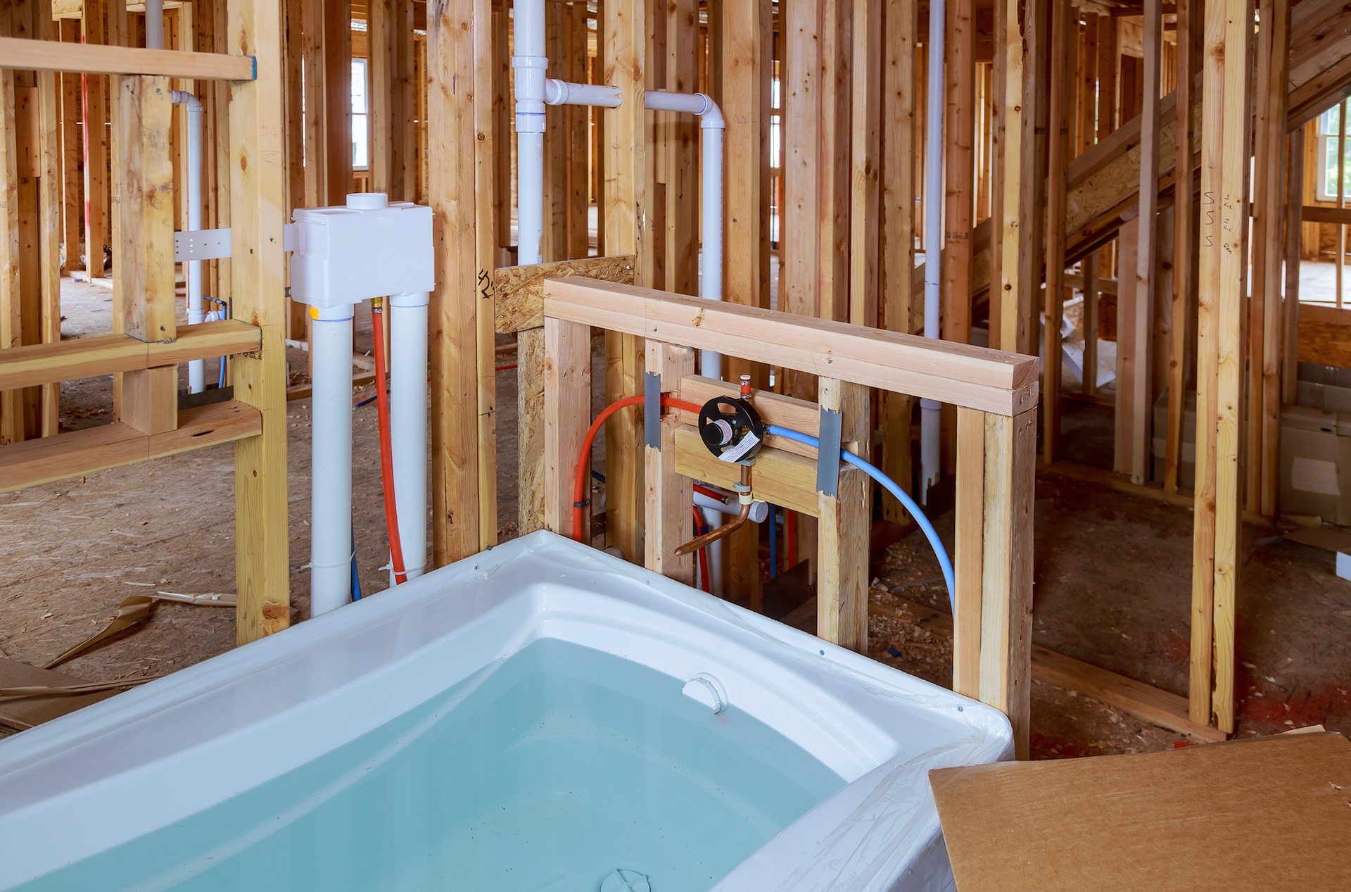 A bathtub is sitting in the middle of a building under construction.
