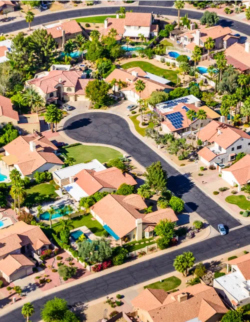 An aerial view of a residential neighborhood with lots of houses and trees