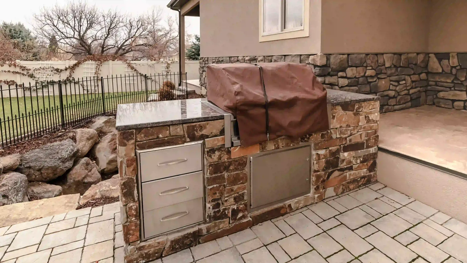 A covered grill with outdoor kitchen cabinetry