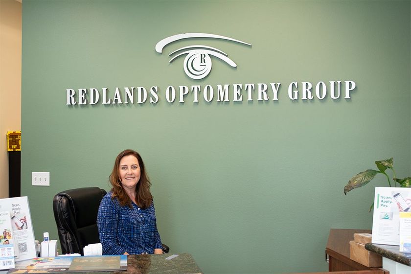 female receptionist  sitting in a chair with a friendly smile