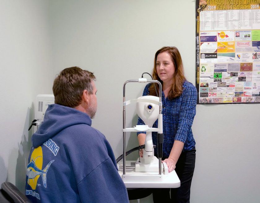Optometrist performing a vision test on a middle-aged man