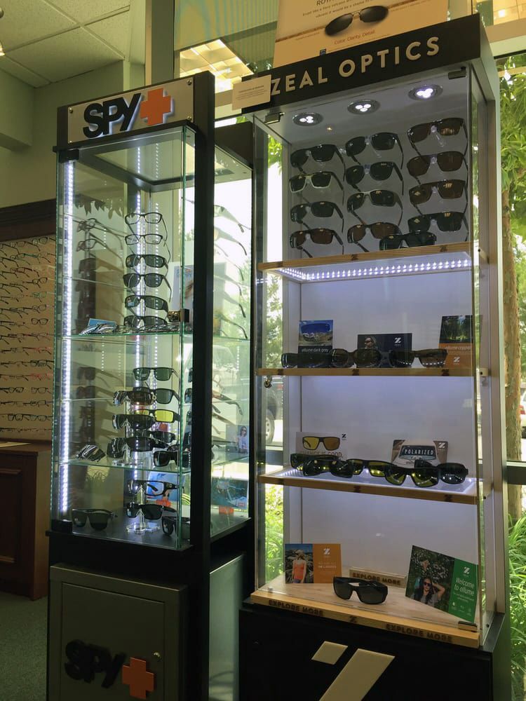 Two glass display cases showcasing a variety of sunglasses from popular brands like SPY and Zeal Optics.