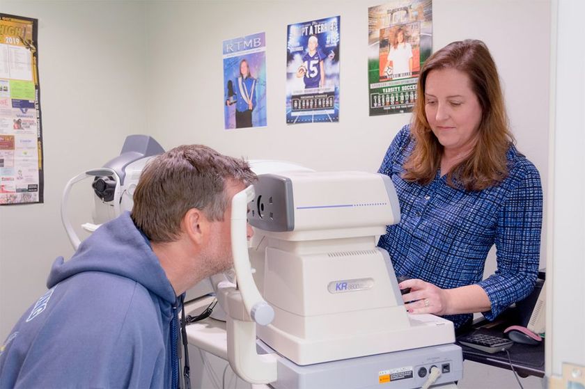 Optometrist performing a vision test on a middle-aged man
