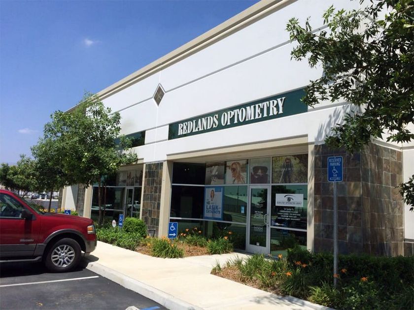 A white building with a green sign that says 