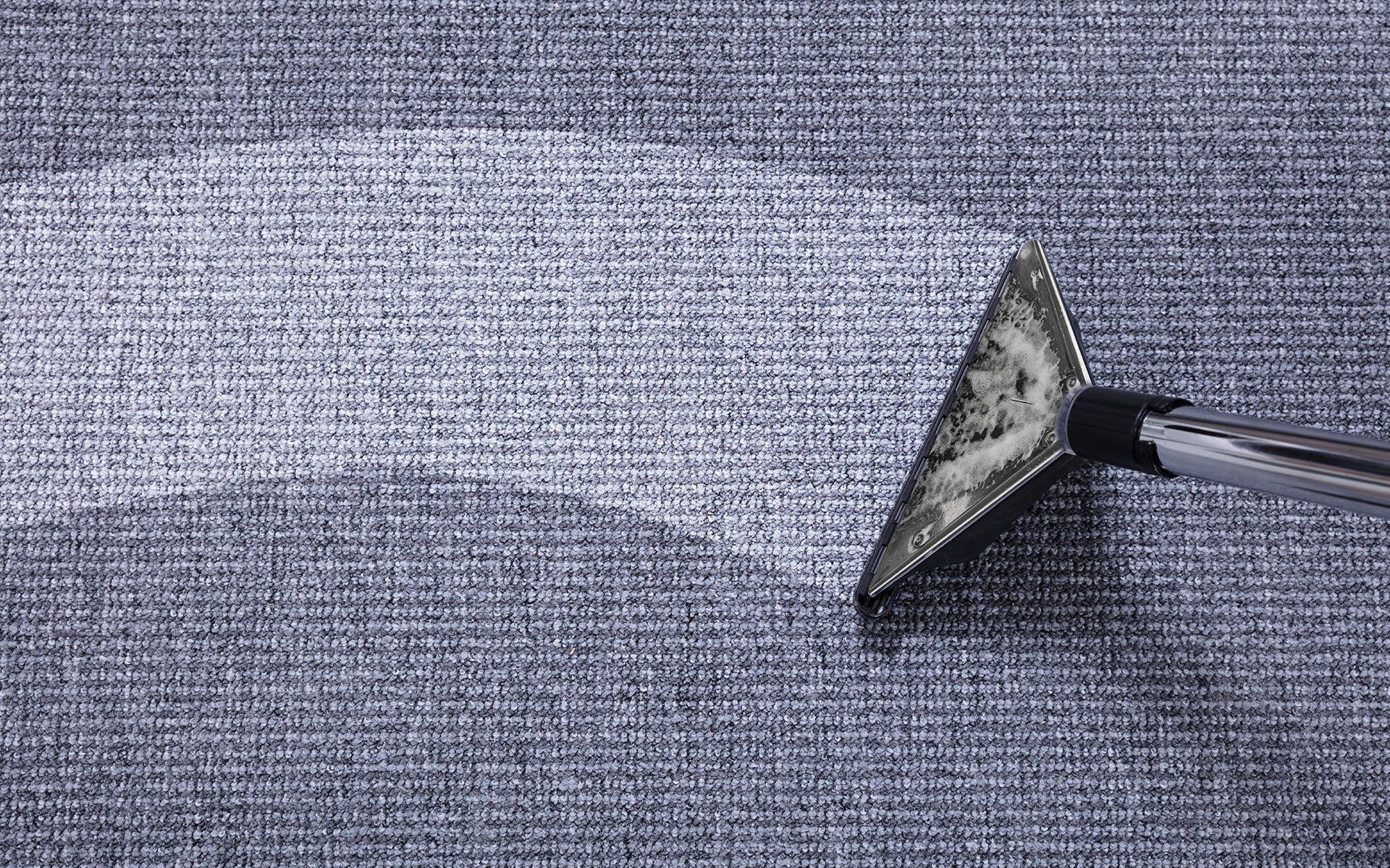 A paint roller applying gray paint to a textured surface