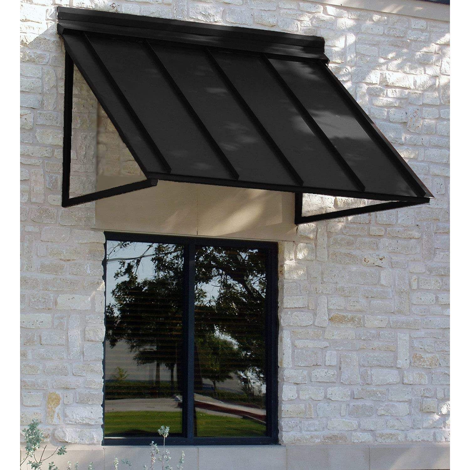 A black metal sloped awning mounted above a window on a light-colored stone exterior wall.