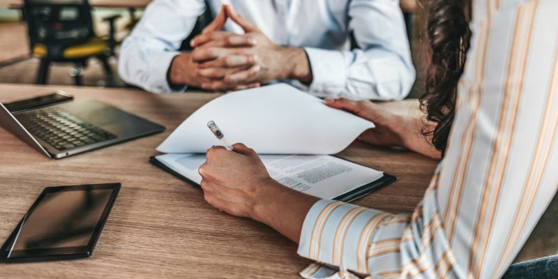 A man and a woman are sitting at a table looking at a piece of paper.