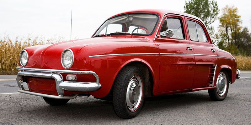 A red car is parked on the side of the road.