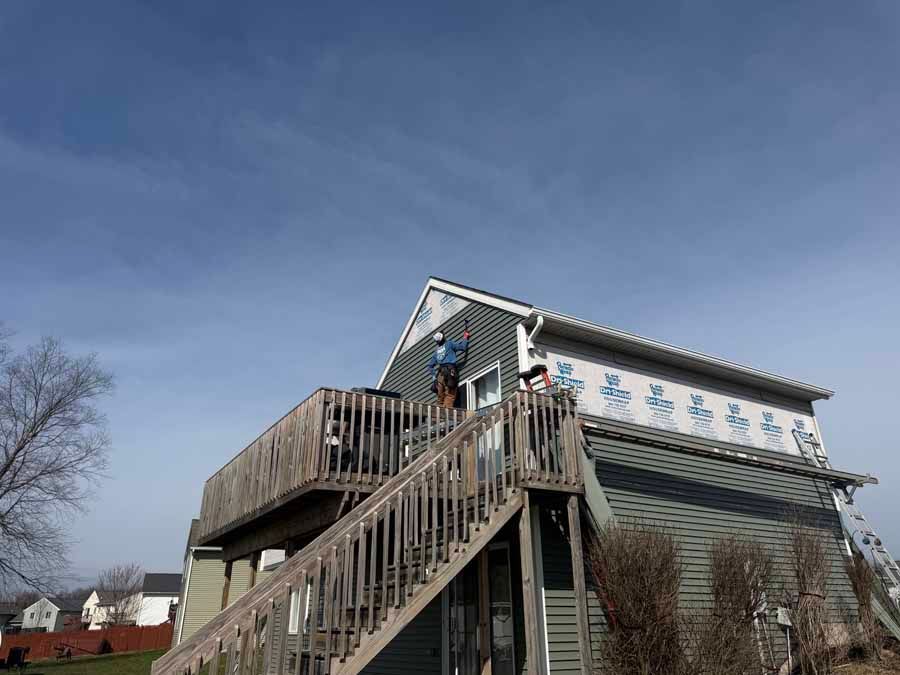 House with exterior staircase and deck under a clear blue sky