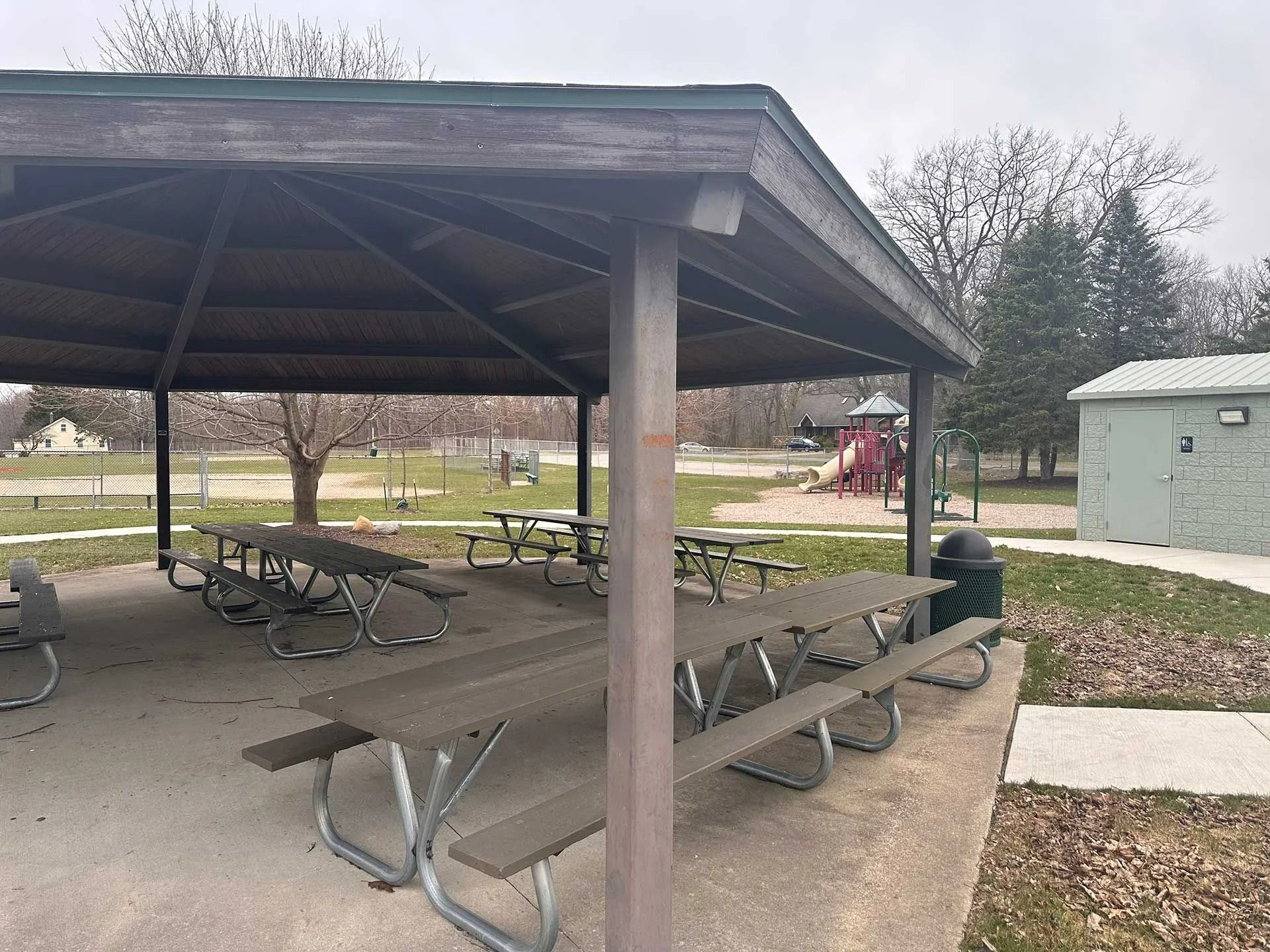Covered park picnic shelter with tables and benches on a cloudy day