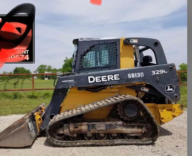 Yellow-and-black John Deere skid steer loader parked on a gravel road beside a field