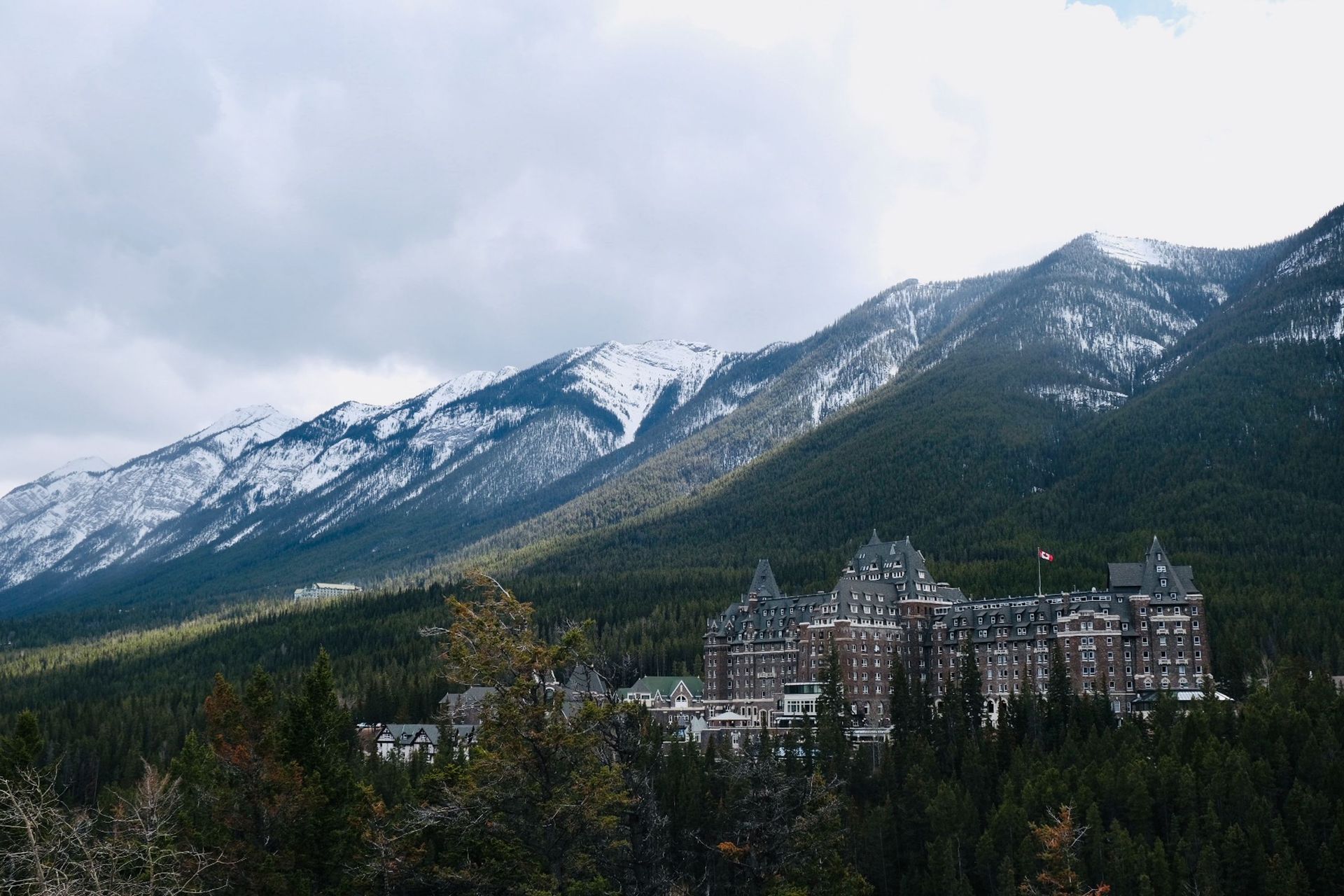 Snowy mountains above a forest and a castle-like resort in the valley