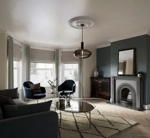 Living room with blue accents, bay window, fireplace, and modern light fixture.