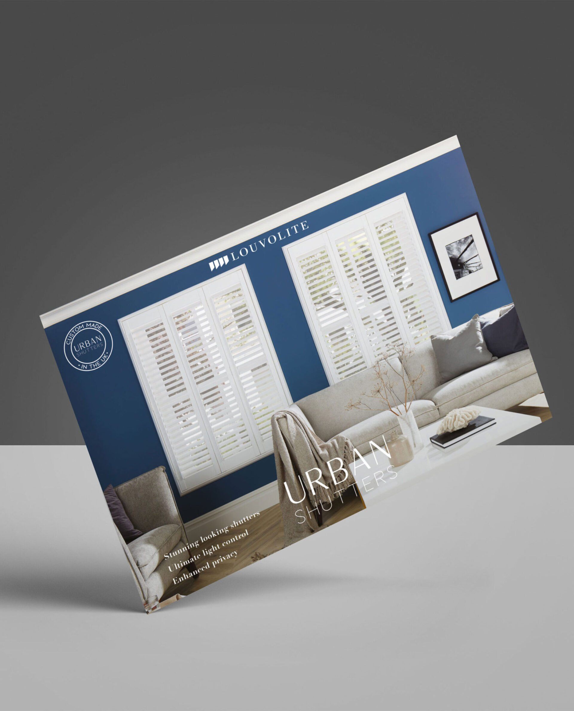 Brochure with a living room interior design featuring blue walls, white window shutters, and a beige sofa.