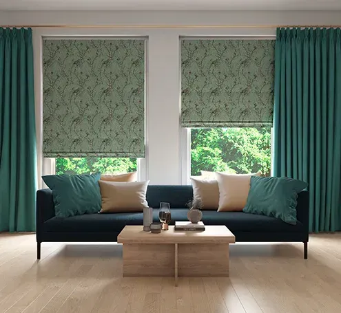 Living room with teal curtains, patterned shades, dark blue sofa, and wooden table.