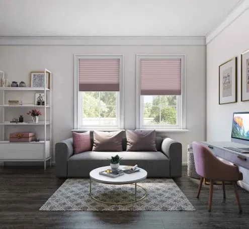 Living room with gray sofa, pink window shades, and a white desk.