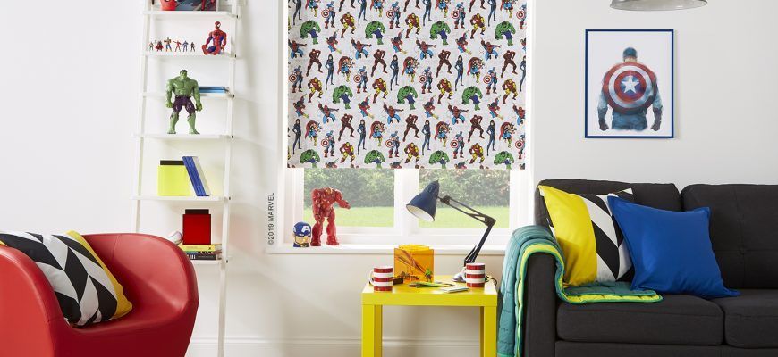 Marvel-themed room with a window featuring superhero characters, a sofa with pillows, and a red chair.