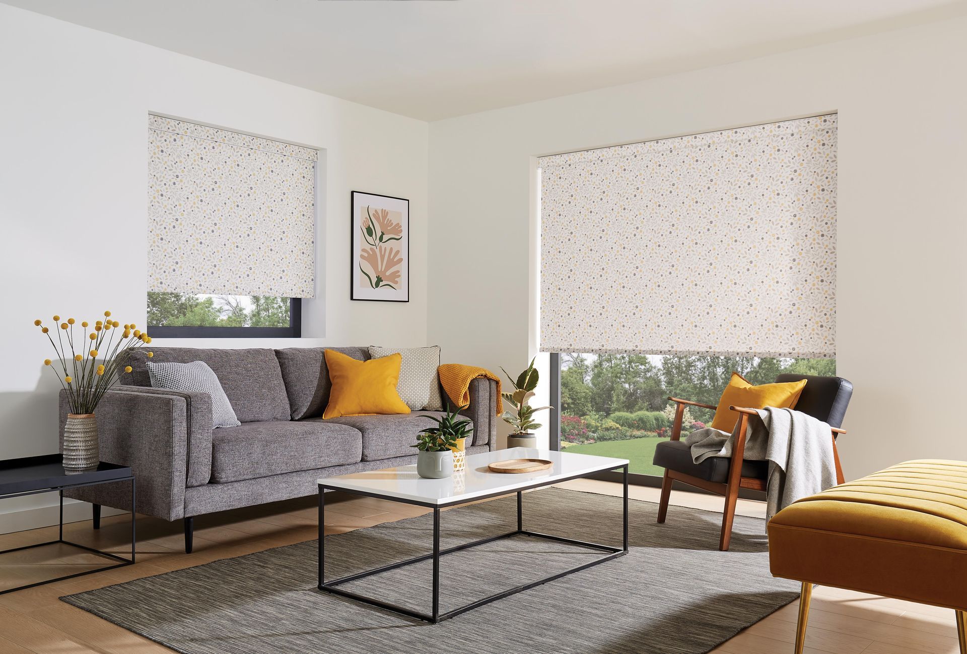 Living room with gray sofa, patterned blinds, and outdoor view.