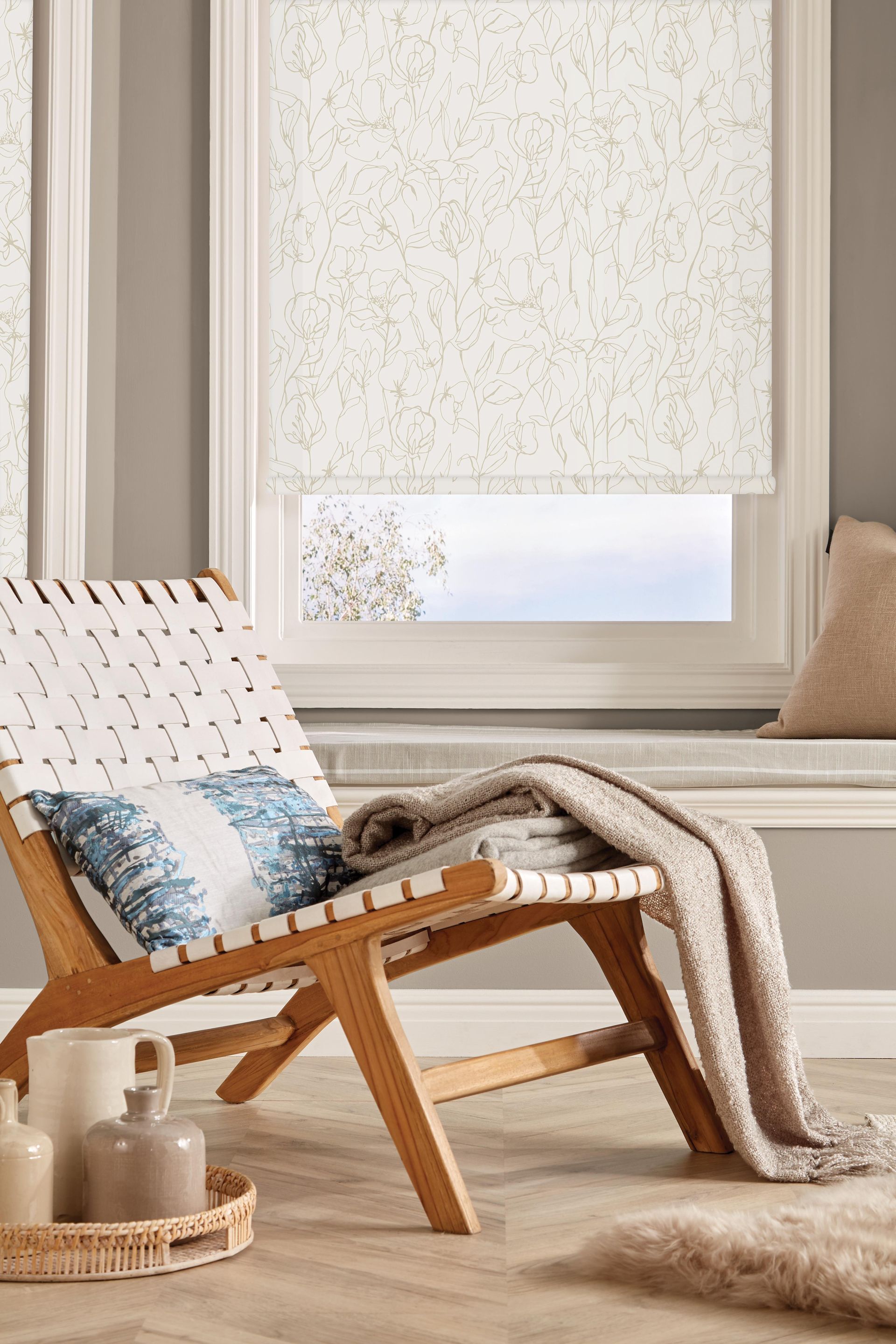 Wooden chair with woven white seat, facing a window with patterned blinds. Neutral color palette.