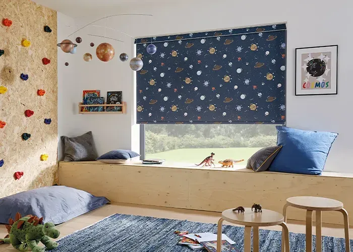 A child's room with a window, bench, and planet-themed blind. Includes a climbing wall, toys, and small tables.