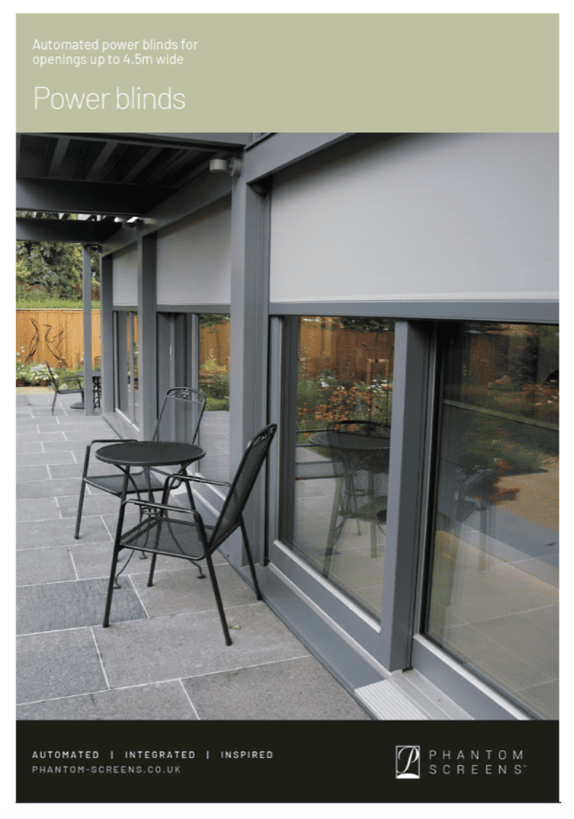 Outdoor patio with power blinds, black chairs, and a table. Gray frame and blinds, green foliage in the background.