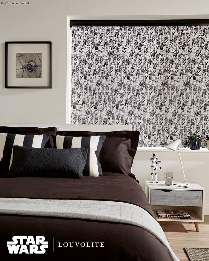 Bedroom with Star Wars-themed blind, dark bedding, framed art, and a white nightstand.