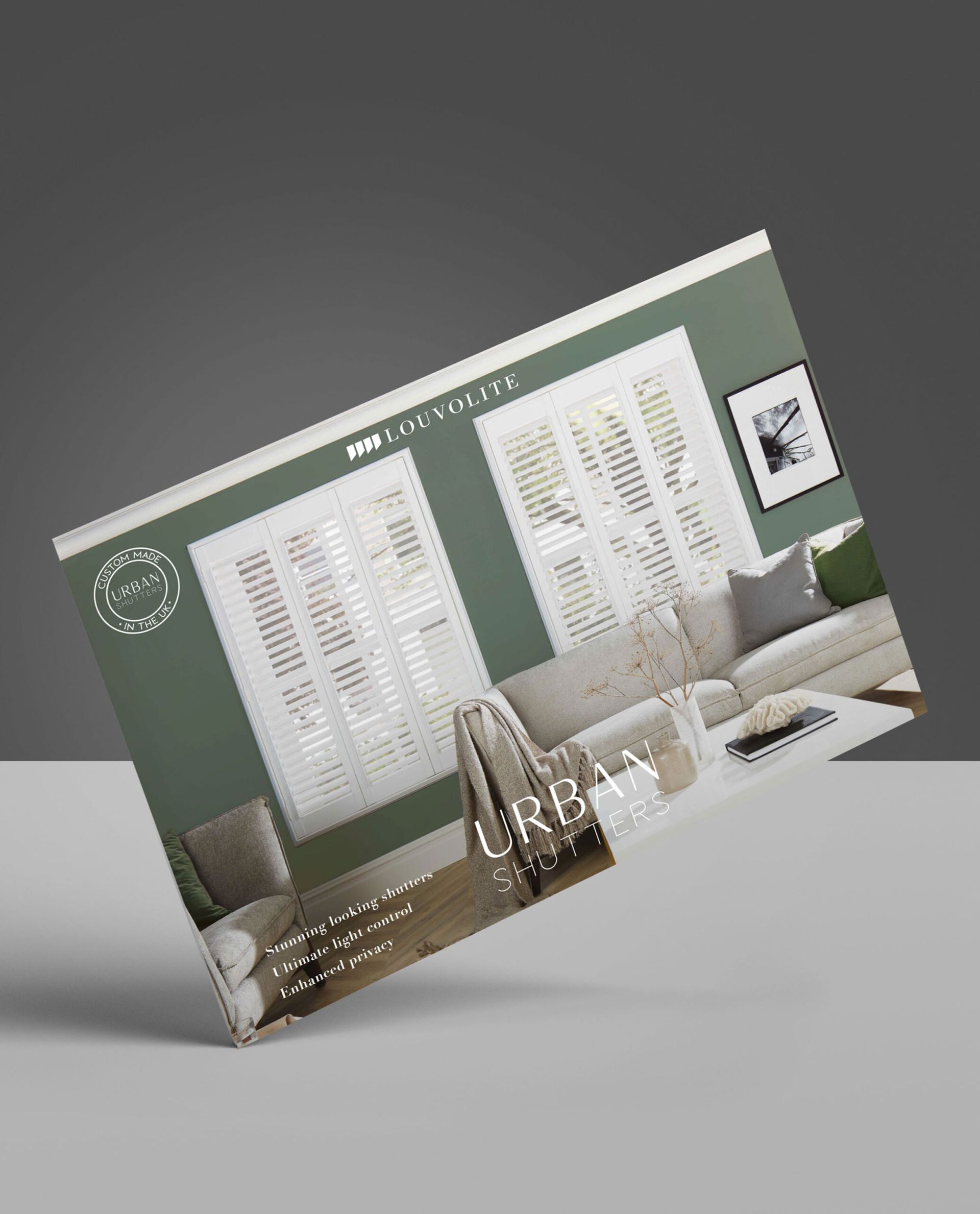 Brochure with a living room scene, featuring white shutters, a light-colored sofa, and a green wall.