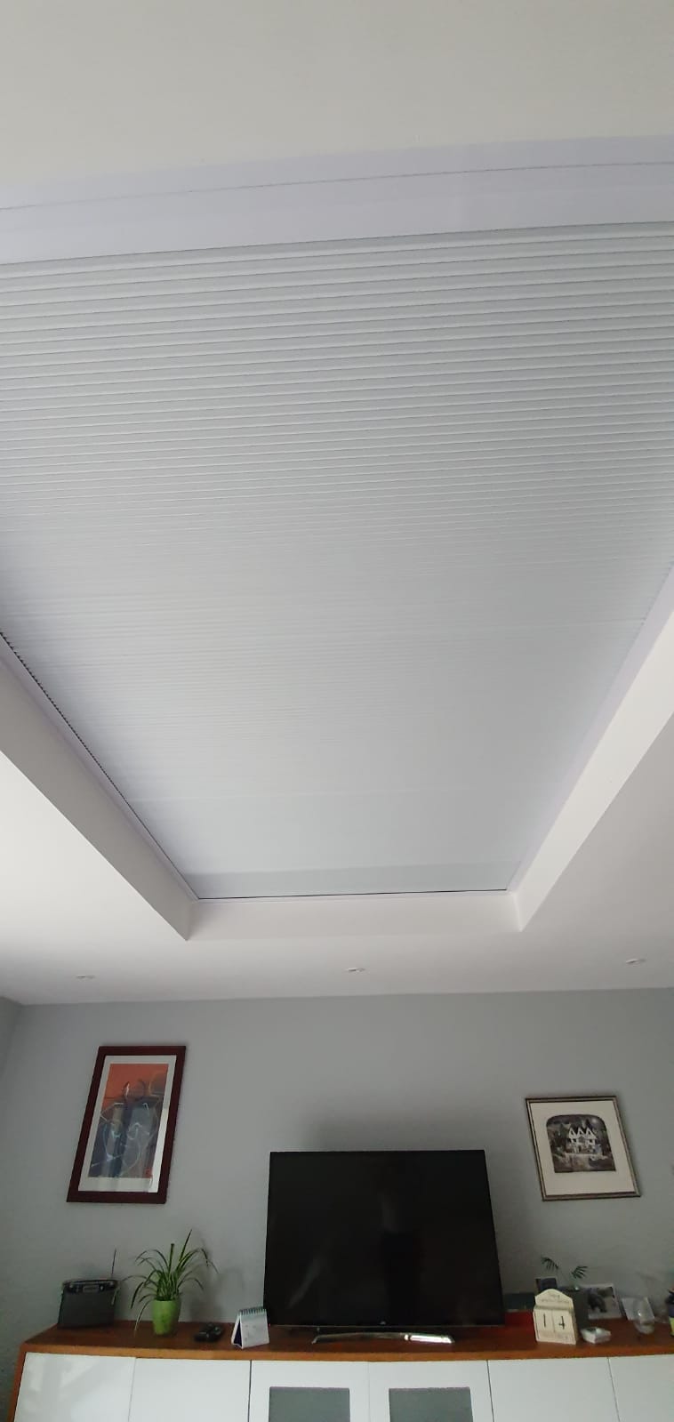 White textured ceiling with recessed lighting above a living room entertainment center.