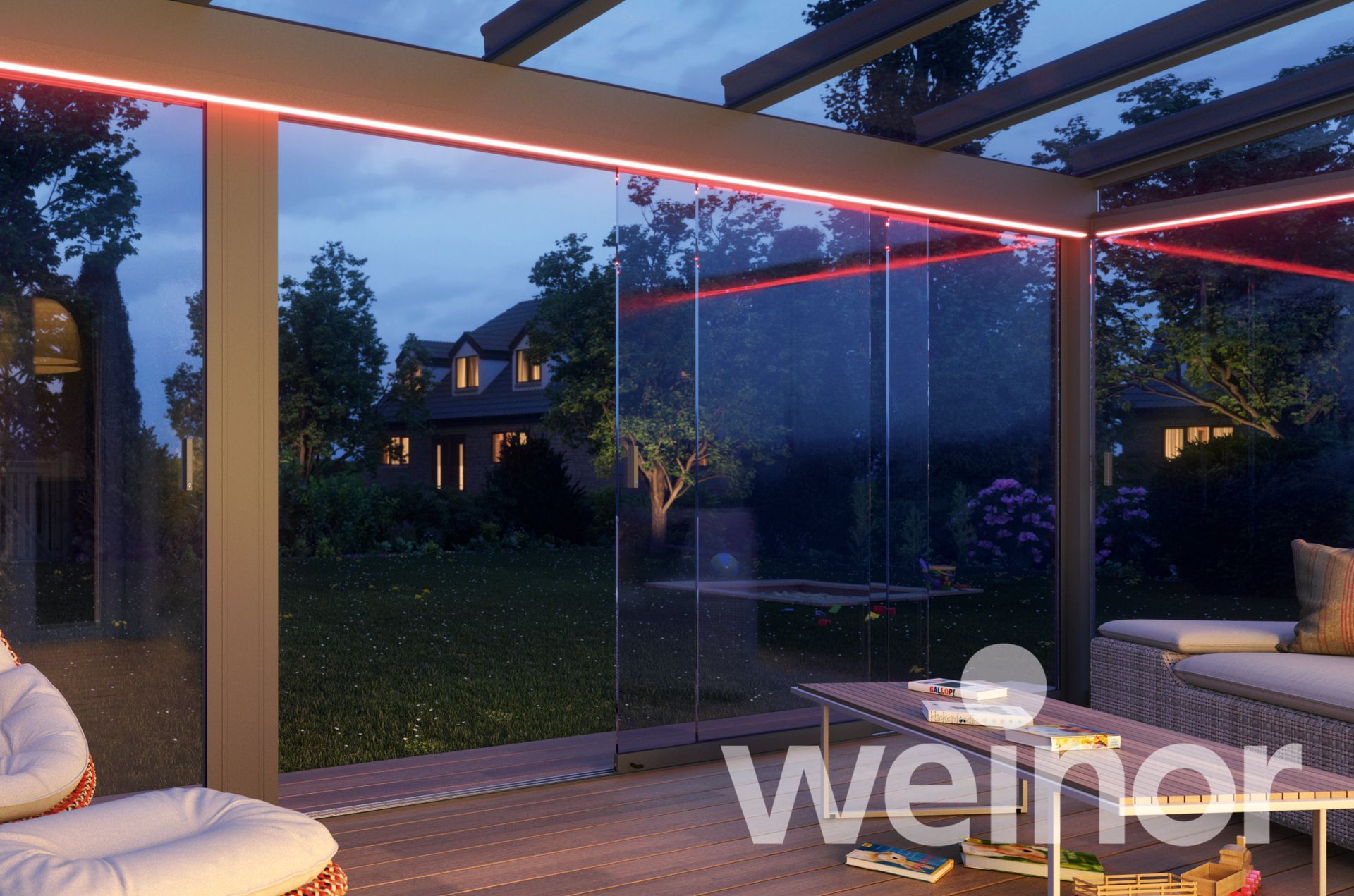 Nighttime patio with glass walls, red lighting, and a view of a house.