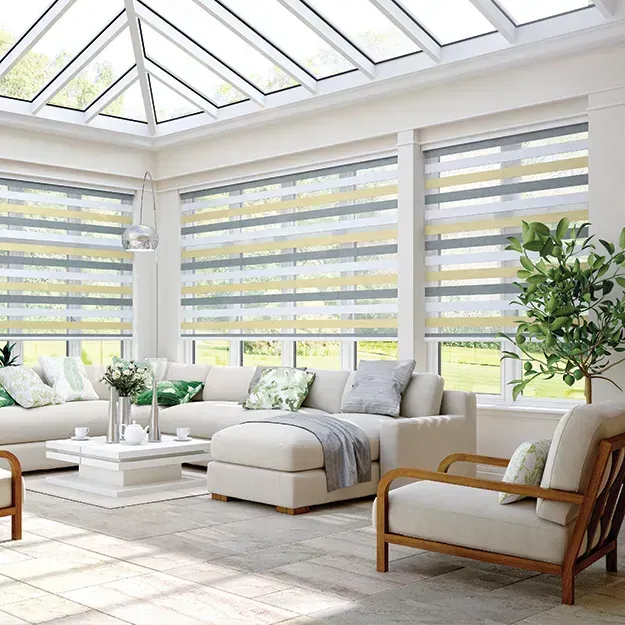 Bright living room with glass ceiling, cream sofa, and striped blinds.
