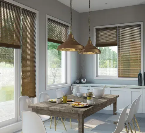 Dining room with wood table, white chairs, and wooden blinds; two gold pendant lights.