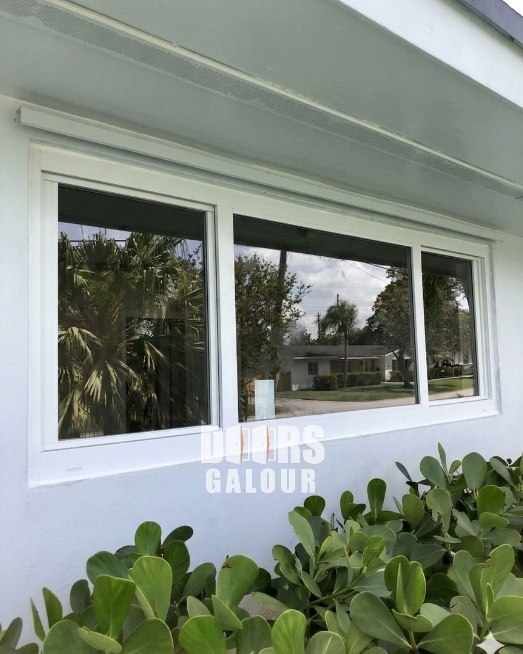 Impact white window installed in a beige wall, with a decorative frame around it.