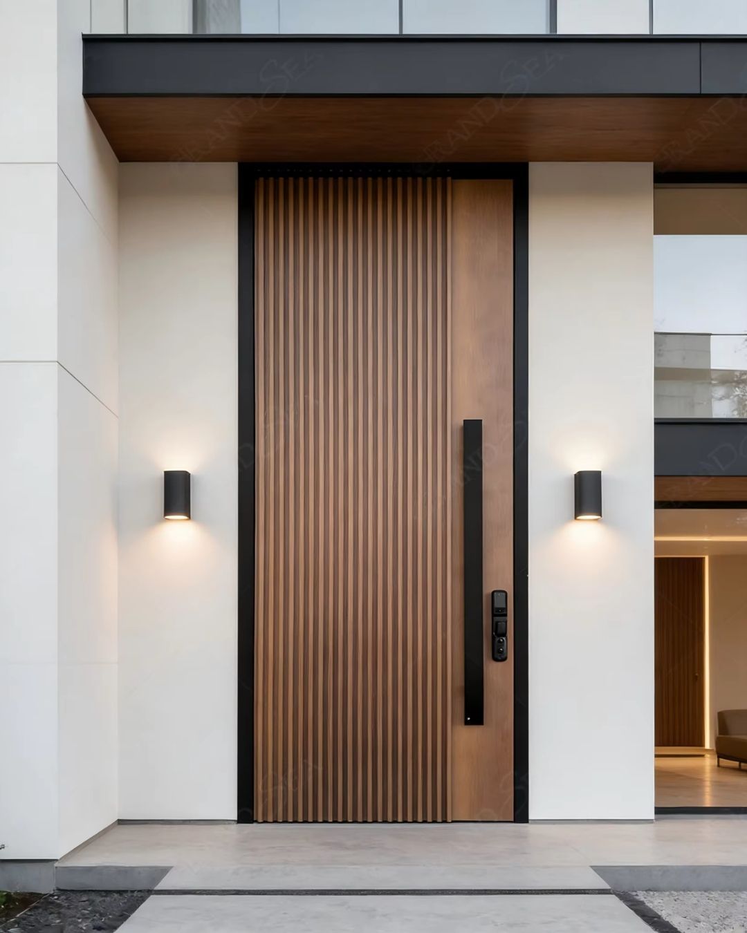 Modern front door with vertical wood slats and black hardware between white walls with sconces