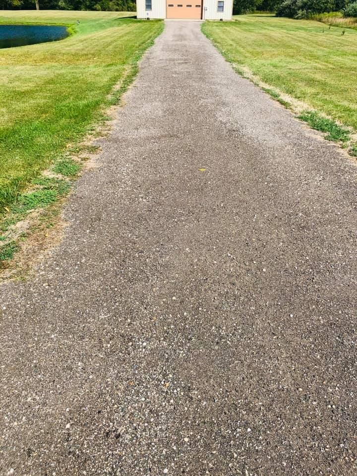 Gravel path through a green lawn leading to a white building with orange doors.
