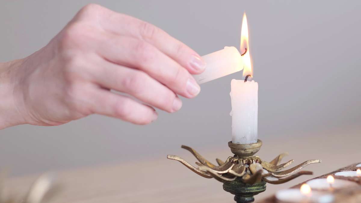 Hands lighting a candle during a witnessed cremation ceremony in El Cajon, California