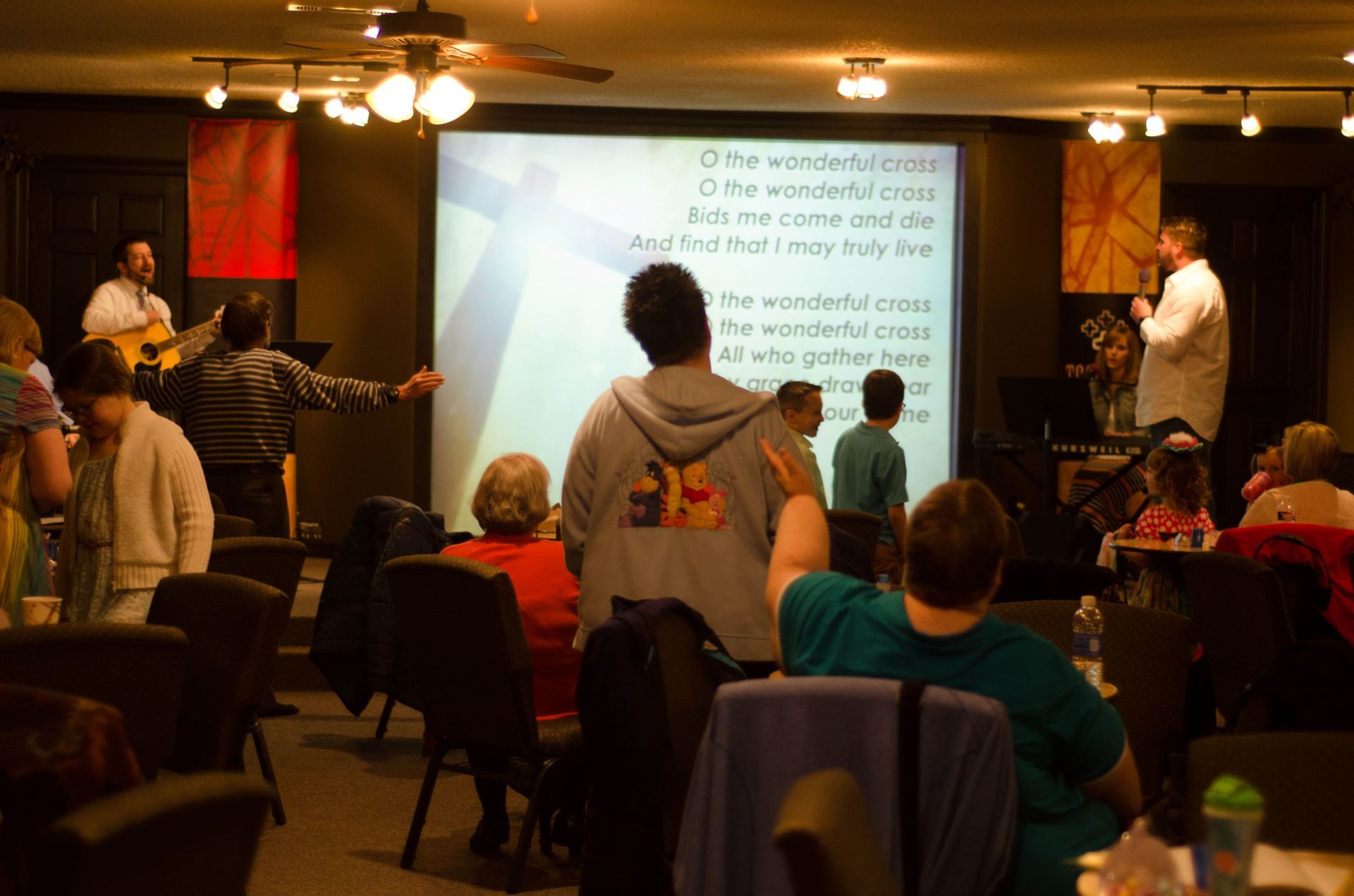 3 families singing and worshipping in the citipointe church sanctuary
