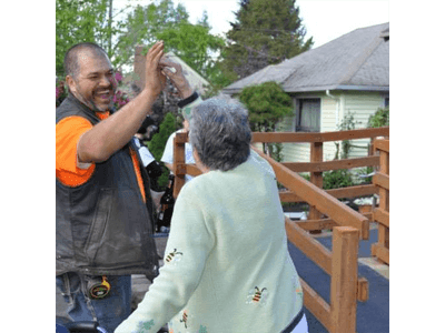 A man is giving an elderly woman a high five