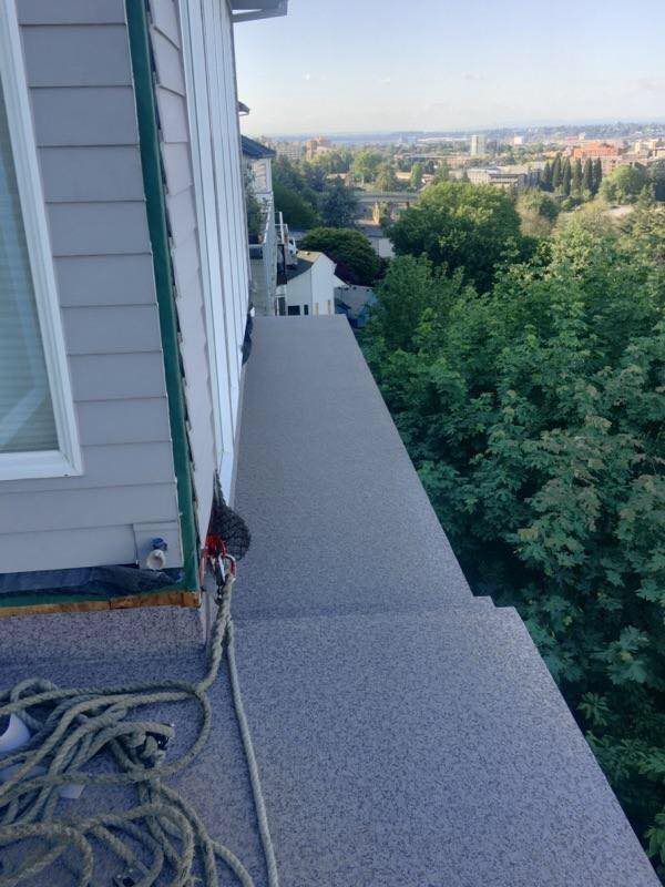 A rope is hanging from the side of a building.