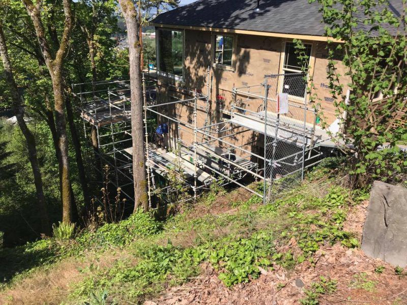 A house is being built on a hill with scaffolding around it.