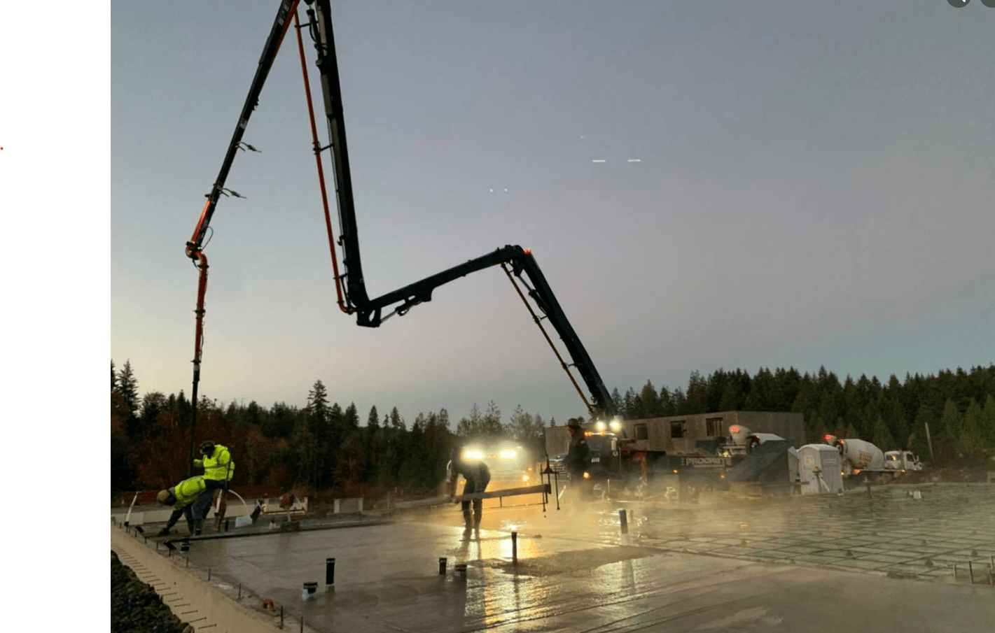 A concrete pump is being used to pour concrete on a construction site.