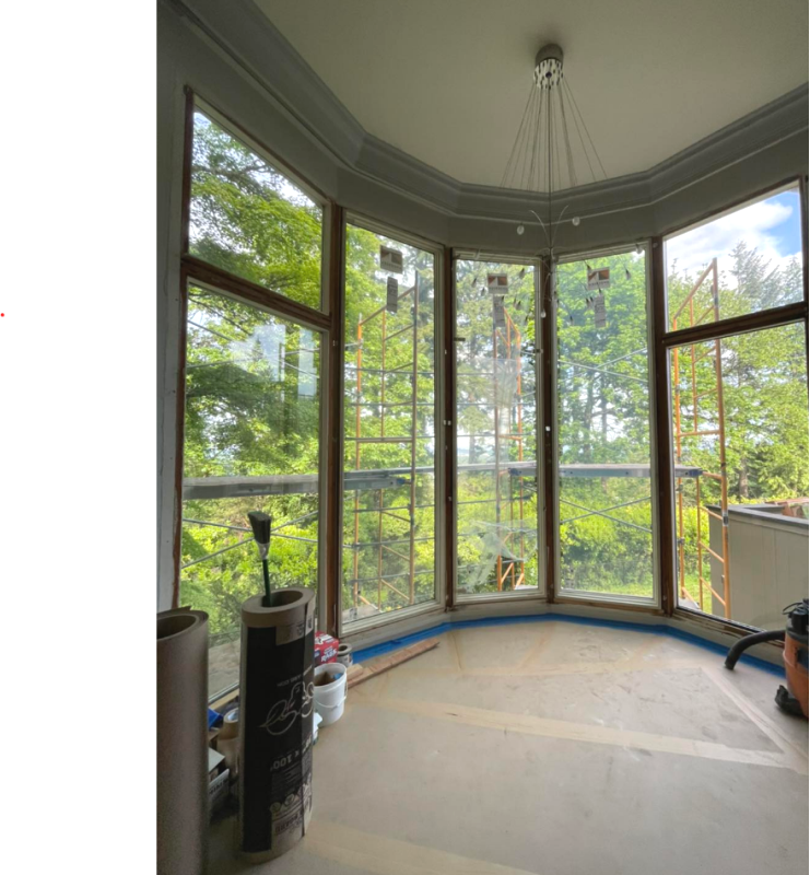 A room with a lot of windows and trees in the background