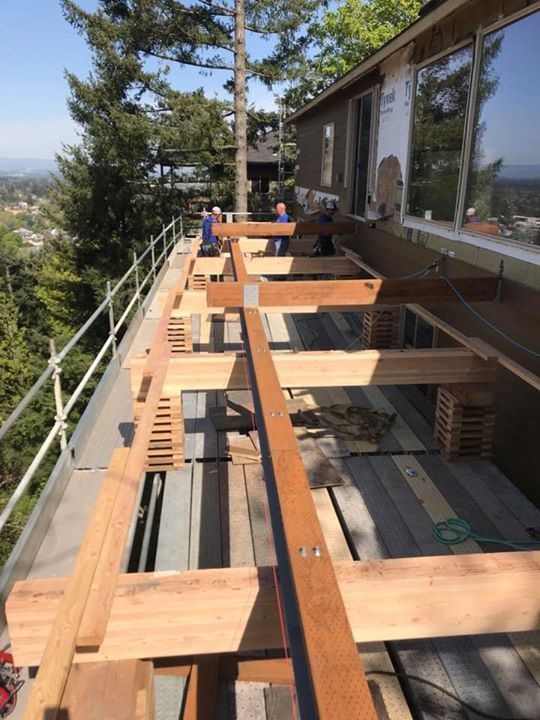 A wooden deck is being built on top of a house
