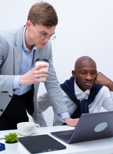 two people reading something on a laptop that we cannot see from our vantage point.