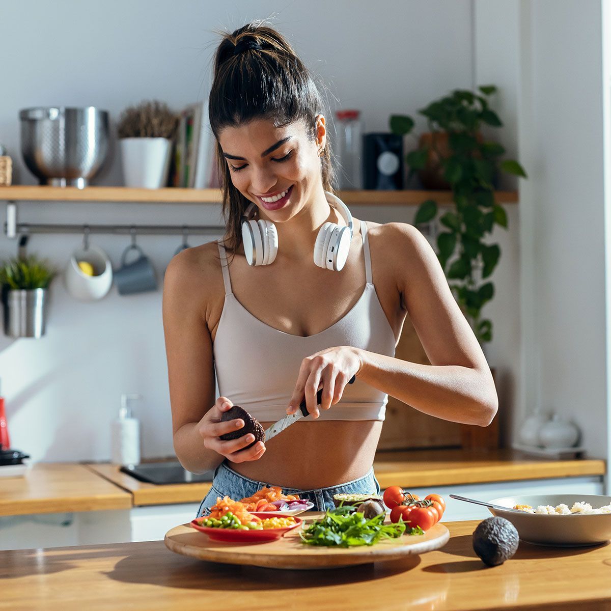 Fintess woman making a healthy poke bowl in the kitchen at home.