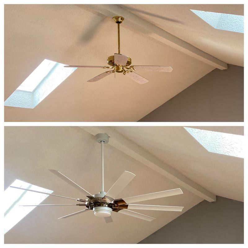 Two ceiling fans in a vaulted room, shown in close-up with skylights and beige ceiling panels.