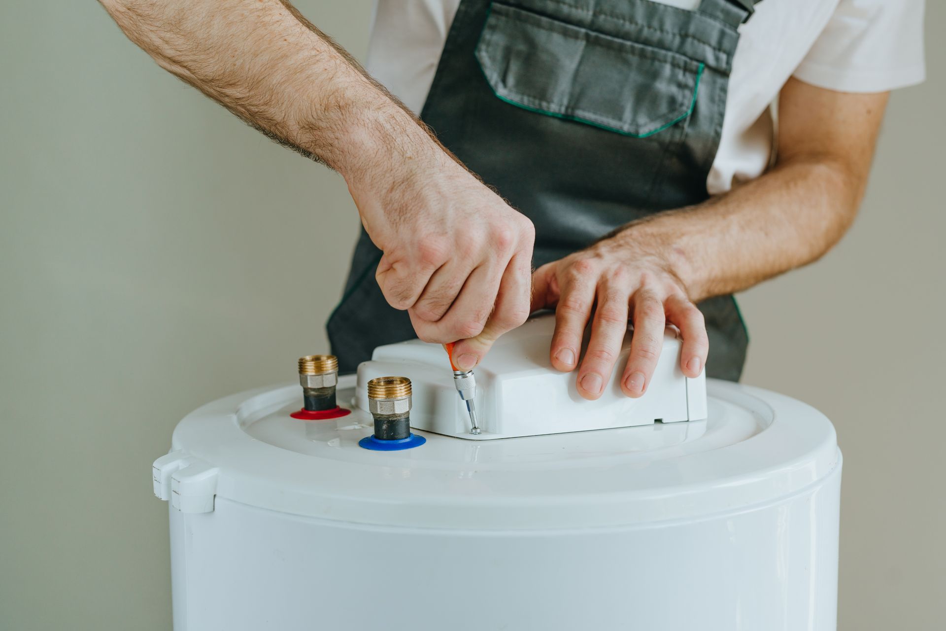 Technician servicing heating unit with hand tool. Technician servicing heating unit with hand tool.